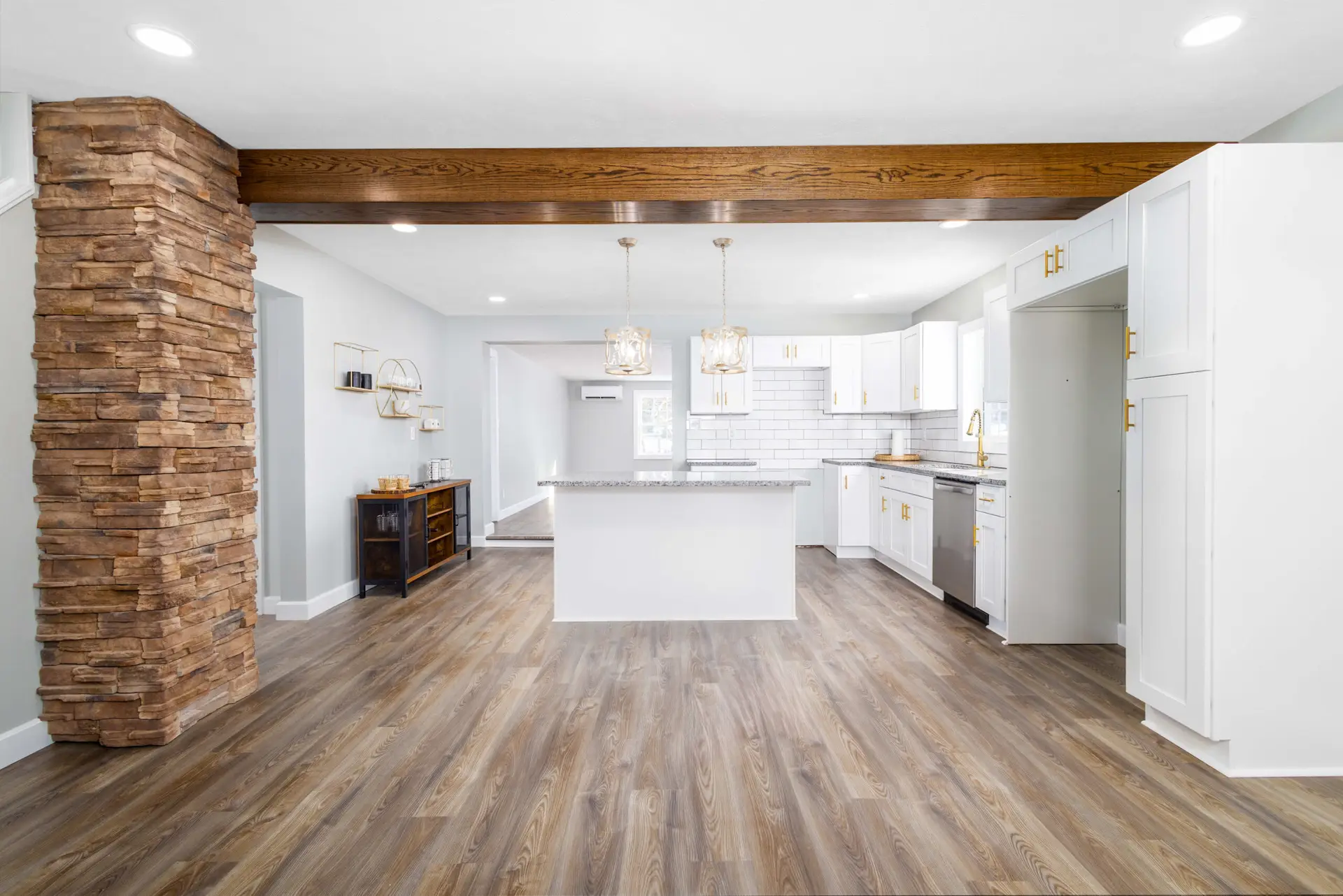 Kitchen with white cabinets, stone column, and reclaimed wood beam