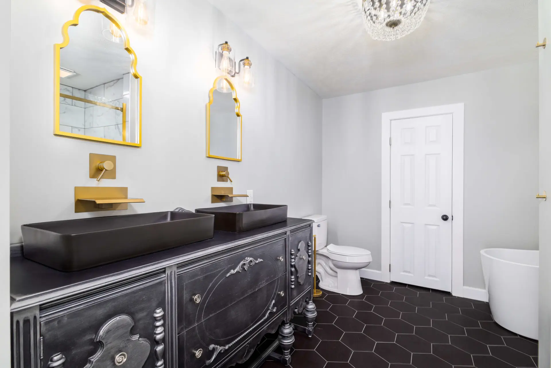 Custom black vanity with gold fixtures and hex tile floor