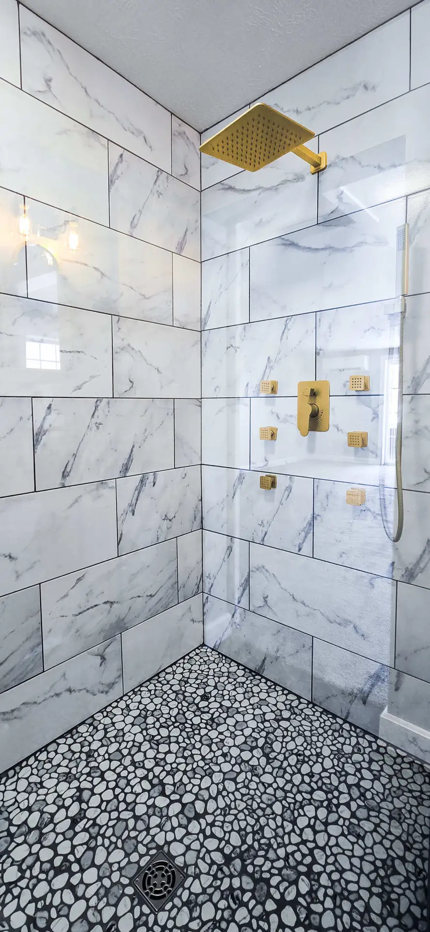 Freestanding soaking tub with dark hex tile flooring
